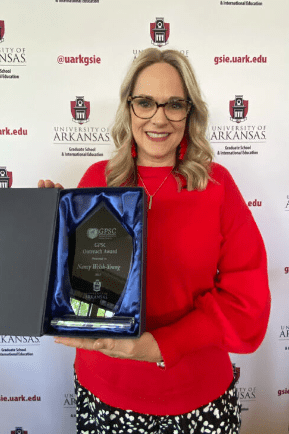 A picture of a white, blonde women in a red top and glasses that won an award for GPSC.