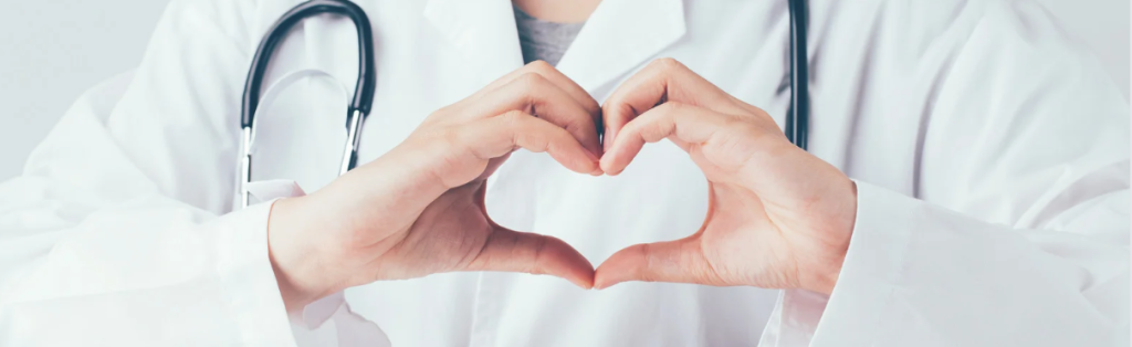 An image of a healthcare professional holding her hands to create the shape of a heart. 